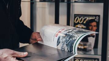Uma pessoa segurando uma revista com a capa mostrando um edifício.