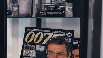 A magazine rack with various car-related magazines, including one prominently featuring a Toyota Crown.