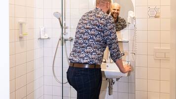 A bathroom with a glass shower enclosure, a sink, and a toilet.