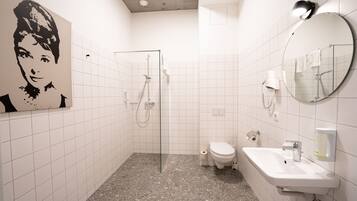 Un baño moderno con ducha, inodoro y lavamanos.