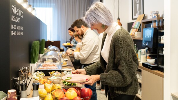 Ein Fr ühstücksbuffet mit verschiedenen Speisen und einer Glastheke.