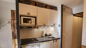 A compact kitchen with white cabinets, a microwave, a sink, and a dishwasher. - Avoriaz - Beautiful renovated apt for 4 people with wifi (Avoriaz)