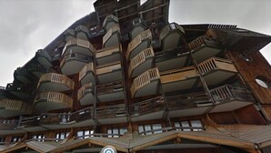 A multi-story building with a unique architectural design featuring balconies and wooden elements. - Avoriaz - Beautiful renovated apt for 4 people with wifi (Avoriaz)