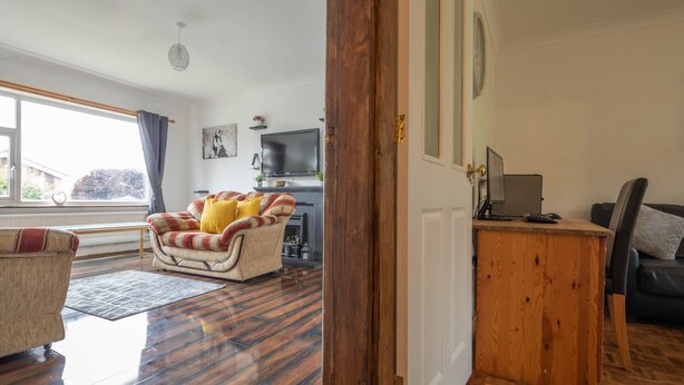 A living room with a sofa, a wooden coffee table, a television, and a fireplace. - 4-bed Detached, Pet Friendly House in Nelson (Nelson)