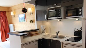 A compact kitchen with a sink, two microwaves, a coffee maker, and a dishwasher. - Avoriaz - Duplex for 6 with balcony and WIFI (Avoriaz)