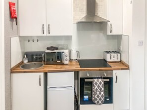 Eine kleine Küchenzeile mit Mikrowelle, Toaster und Spüle.