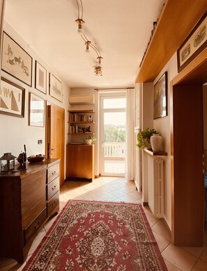 Stunning views of lush greenery await from the balcony, accessible through this inviting hallway.