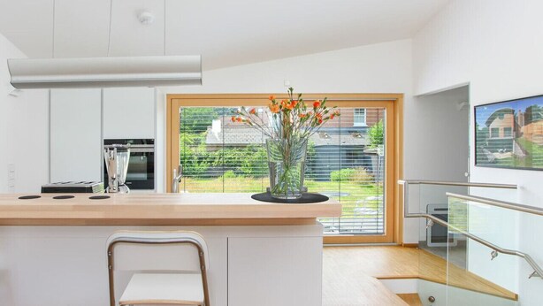 A modern kitchen with a large island, a built-in oven, and a view of a garden through a large window. - Contemporary bolthole, short walk from City Sleeps 2+1 (Canterbury)