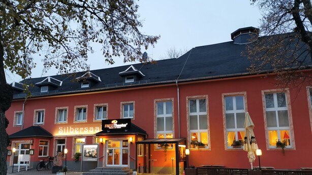 Un bâtiment rouge avec une enseigne indiquant « Silbersaa » et « FressTheater ».
