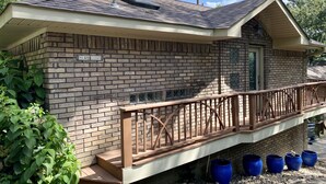 Une petite maison d’hôtes en briques, dotée d’un balcon, d’une cheminée et d’une enseigne indiquant « Maison d’hôtes ».