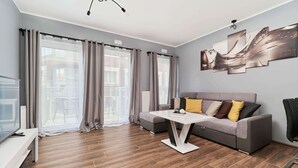 Ein modernes Wohnzimmer mit Sofa, Couchtisch und Fernseher.
