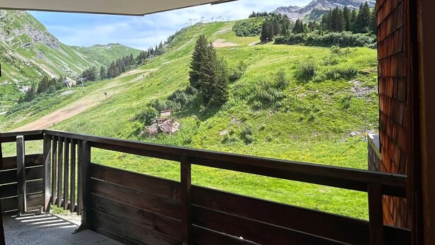 Uma varanda com vista para uma paisagem montanhosa.