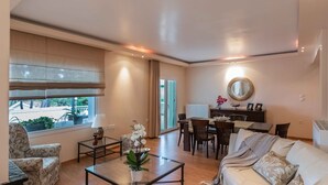 A modern living room with a sofa, coffee table, and dining area.