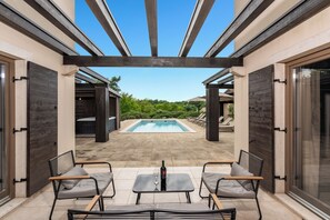 An outdoor patio with a pool, two tables, and four chairs. - Villa Santi with a hot tub, sauna, and heated pool from May through the end of September (Svetvinčenat)