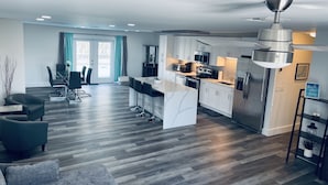 A modern kitchen with white cabinets, stainless steel appliances, and a central island.