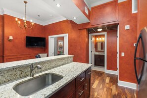 A kitchen with granite countertops, a stainless steel sink, and wooden cabinets.