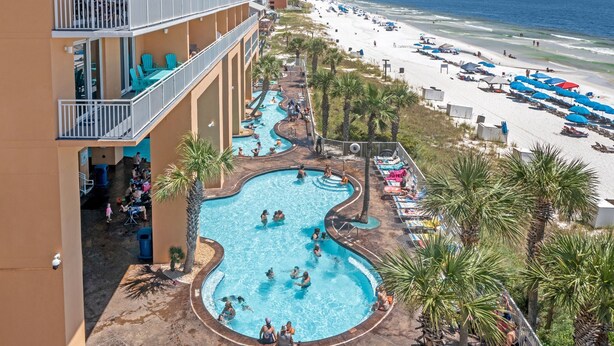 A hotel with a pool area, beach access, and multiple balconies.