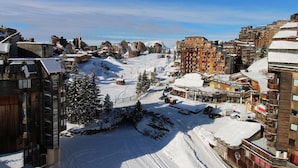 Una località sciistica innevata con edifici in legno e una seggiovia.