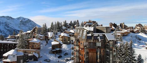 A snow-covered mountain town with wooden buildings and a mix of modern and traditional architecture.