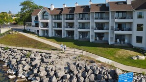 A multi-story building with balconies and outdoor seating. - Lake Charlevoix Views | Private Balcony | Pool, Hot Tub, Sauna (Charlevoix)