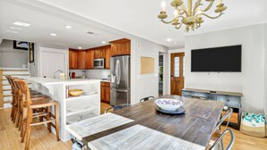 A modern kitchen with wooden cabinets, stainless steel appliances, and a dining area with a wooden table and chairs. - Walk to Beach | Private Pool | Pet Friendly (Hilton Head Island)