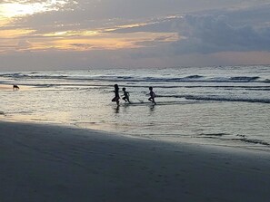A beach scene with waves and a sunset.