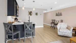 A modern kitchen with a central island, bar stools, and pendant lighting. - 112 EWI Lake Charlevoix View Condo | Pool, Hot Tub, Sauna | Fireplace (Charlevoix)