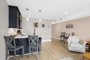 A modern kitchen with a central island, bar stools, and pendant lighting. - 112 EWI Lake Charlevoix View Condo | Pool, Hot Tub, Sauna | Fireplace (Charlevoix)