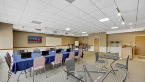 Une salle de conférence avec une longue table, des ordinateurs portables et des chaises.