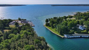 Vue aérienne d’une propriété au bord du lac, avec un quai, une petite jetée et un bateau.