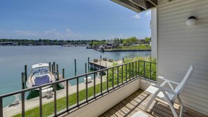 A balcony with a view of a marina and a river. - 228 Edgewater Inn | Peaceful Lake Charlevoix Escape | Pool, Hot Tub, Sauna (Charlevoix)
