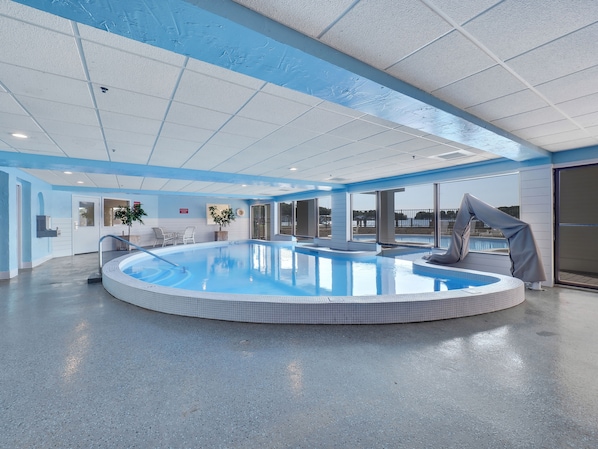 Una amplia piscina cubierta con vista despejada al exterior.