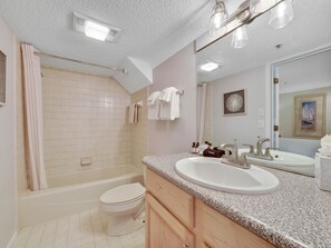 A modern bathroom with a bathtub, toilet, and vanity with a sink and mirror. - Edgewater 357 | Downtown Charlevoix | Pool, Hot Tub, Sauna (Charlevoix)
