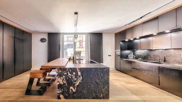 A modern kitchen with a central island, dark cabinetry, and a wooden floor. - YOUR SOLUTION TO A LUXURY STAY- 250M2 TOP LUXURY CHAMPS ELYSEES (Paris)