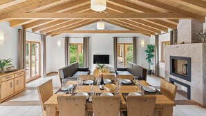 A spacious dining area with a high wooden ceiling, a central TV, and a fireplace. - Villa Bonassini with whirlpool, sauna and 4 bedrooms  (Svetvinčenat)