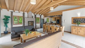 A spacious living area with a wooden ceiling, a sofa, a dining table, and a kitchen in the background. - Villa Bonassini with whirlpool, sauna and 4 bedrooms  (Svetvinčenat)