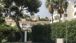 A swimming pool with a view of white buildings and palm trees in the background.