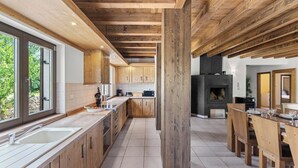 A spacious kitchen with wooden cabinets, a large island, and a fireplace.