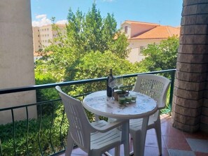 Enjoy a peaceful retreat on this balcony with a table for two and a beautiful view of the surrounding greenery.