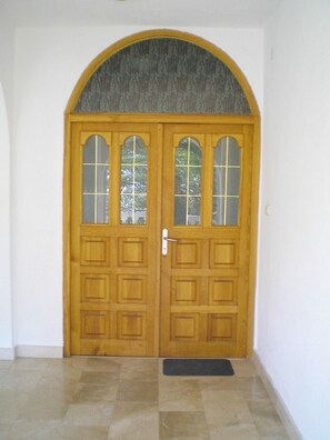 Stylish entrance with a semi-circular arch and grid-patterned glass panels.
