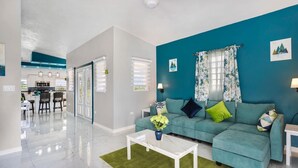 A modern living room with a teal sofa, a white coffee table, and a green rug. - Fortune Rise. Car Rental available  (Mount Fortune)