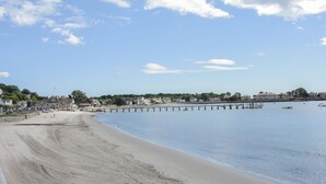 A beach with a pier extending into calm waters, surrounded by residential buildings. - 3 bedroom condo nestled in Historic fishing village - dog friendly (Swampscott)