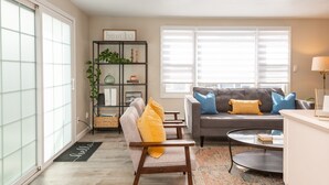 A living room with a sofa, armchairs, a coffee table, a bookshelf, and a window with blinds. - 3 bedroom condo nestled in Historic fishing village - dog friendly (Swampscott)