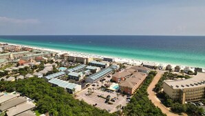 Un complexe hôtelier comprenant plusieurs bâtiments, une plage et offrant une vue dégagée sur l’océan.