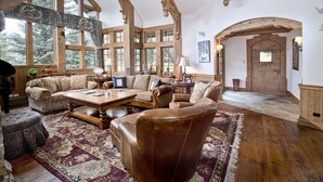 A spacious living room with high ceilings, large windows, and a cozy fireplace. - 349 Holden Rd. 5 Bedroom Home by RedAwning (Avon)