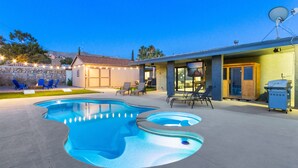 Un jardin avec une piscine, des chaises longues, un barbecue et une antenne parabolique.