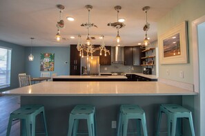 Enjoy cooking and socializing at the central island bar area with a refrigerator, oven, and microwave.