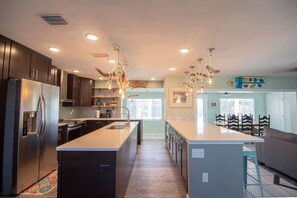 A modern kitchen with a central island, stainless steel appliances, and pendant lighting.