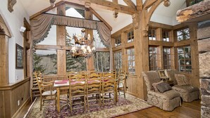 A rustic interior with a wooden dining table, chairs, and a sofa. - Spectacular house on shuttle route, grand piano, pool table (Beaver Creek)