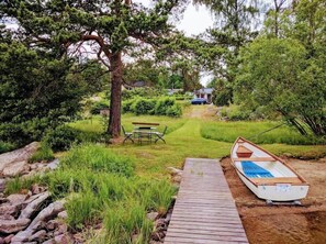 Enjoy a peaceful retreat on the deck, surrounded by lush trees and a serene grassy area.